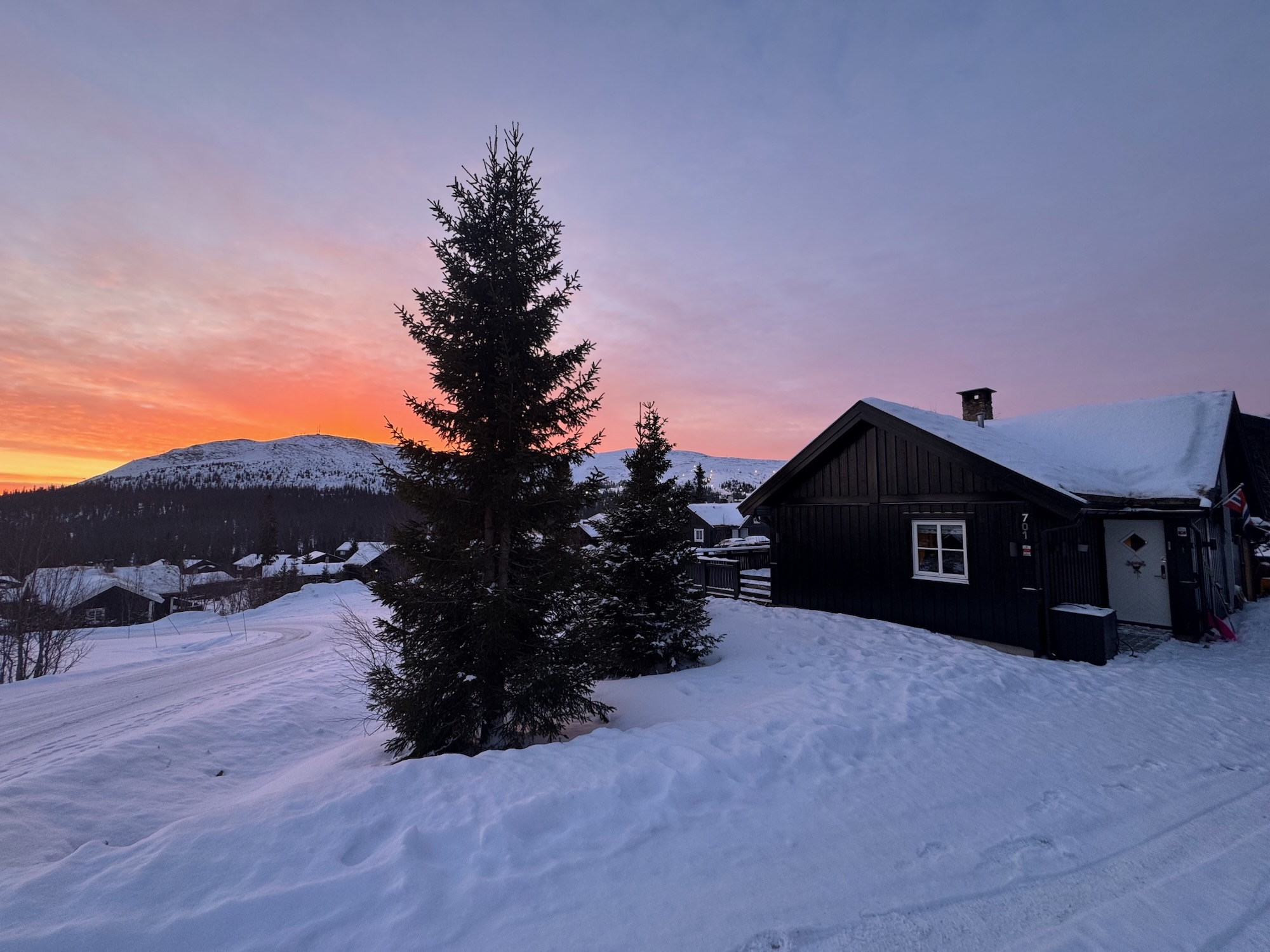 Exterior view of the cabin at sunset with mountain views.
