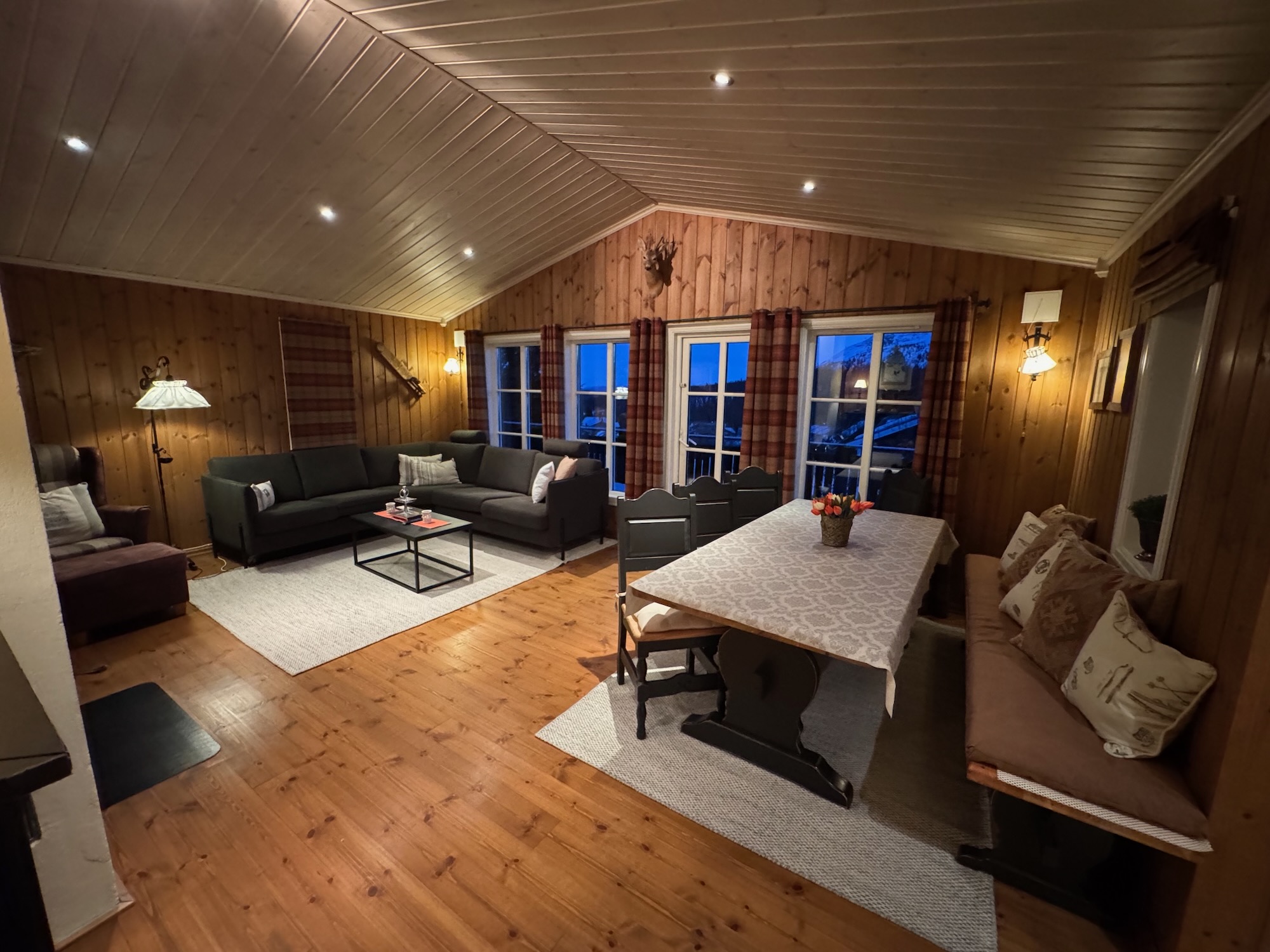 Spacious living and dining area with seating, dining table and French doors.